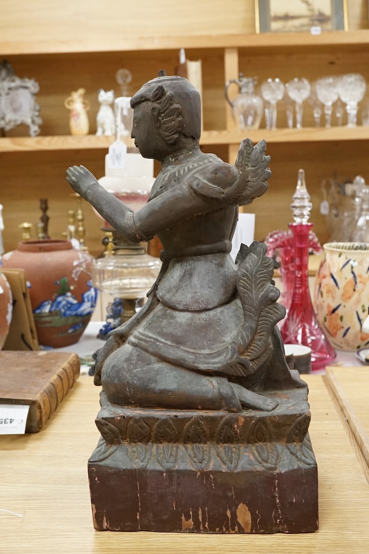 A Thai lacquered wood figure of a kneeling deity, 46cm high.